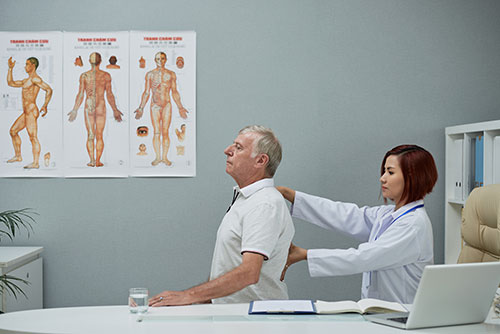 ABC chiropractor checking spine of patient